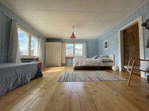 A bedroom with a bed, a chair, a window, and a door. - Ferienhaus Casa Marili Schmed, Sevgein, (Sevgein), 27001B by Interhome (Sevgein)