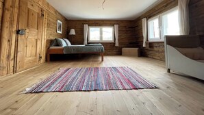 Um quarto com painéis de madeira, uma cama, uma janela e um abajur.