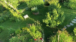Um jardim com diversas plantas e um espaço de estar pequeno.