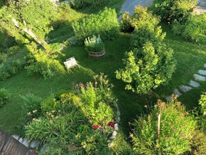 Ein Garten mit vielfältigen Pflanzen und einer kleinen Sitzecke.