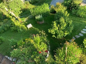 A garden with a variety of plants and a small wooden bench. - Ferienhaus Casa Marili Schmed, Sevgein, (Sevgein), 27001B by Interhome (Sevgein)
