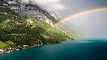 Ett kustlandskap med ett berg, en sjö och en regnbåge.