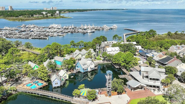 A marina with boats, a dock, and residential buildings. - BayviewPalms - Sandestin 2BR Bayview + Golf Cart (Miramar Beach)