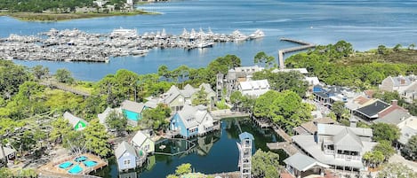 A marina with boats, a dock, and residential buildings.