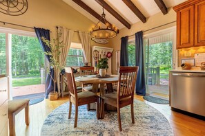 A dining area with a wooden table, chairs, and a chandelier. - Charming 3-bedroom house in Arrowhead Lake (Pocono Lake)