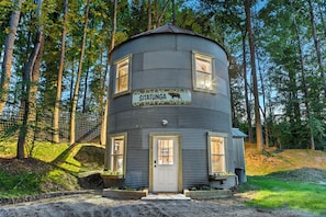 A cylindrical building with a sign reading 'SITATUNG' and a deer image, surrounded by trees.