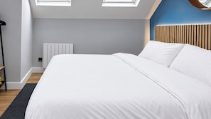 A modern bedroom with a large bed, skylight, radiator, and a wooden headboard. - Central 1-Bed Apartment, Sleeps 3 near Parking (Bournemouth)