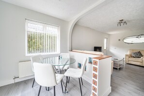 Un espace de vie moderne comprenant un coin repas, un canapé et un îlot de cuisine.