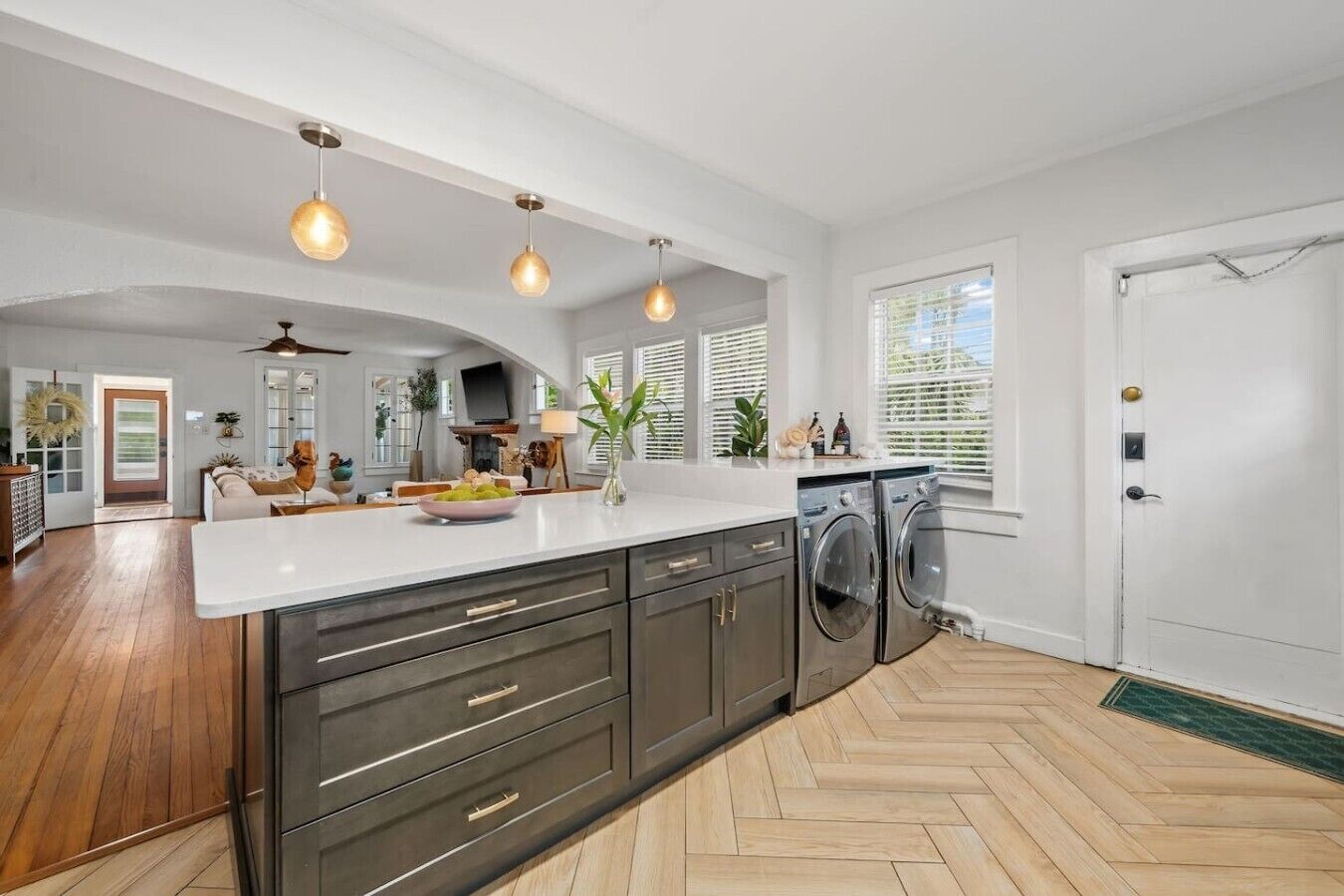 A modern kitchen with a central island, built-in appliances, and pendant lighting.