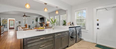 A modern kitchen with a central island, built-in appliances, and pendant lighting.