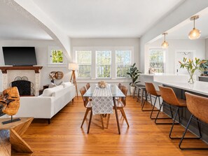 A modern interior with a dining area, kitchen, and living space. - Casa Serena · Historic Spanish Home · SoSo (West Palm Beach)