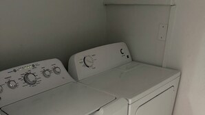 Een wasserette met twee wasmachines en een droger.