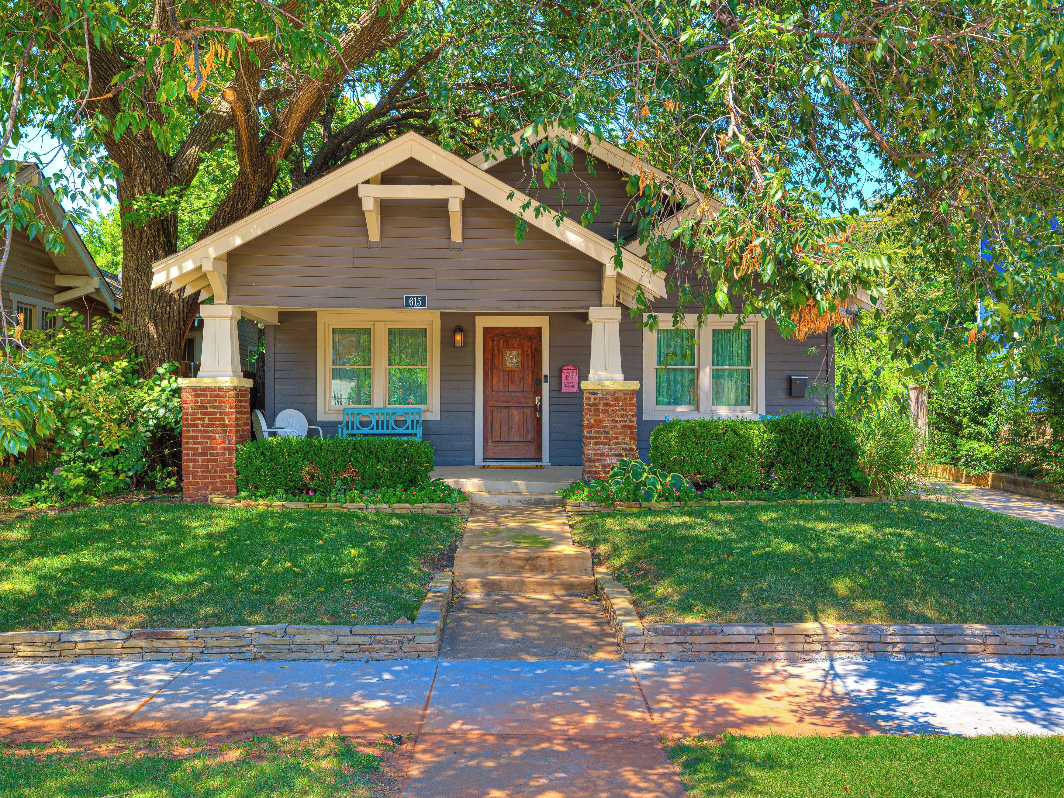 A residential house with a front porch, a mailbox, and a number sign.