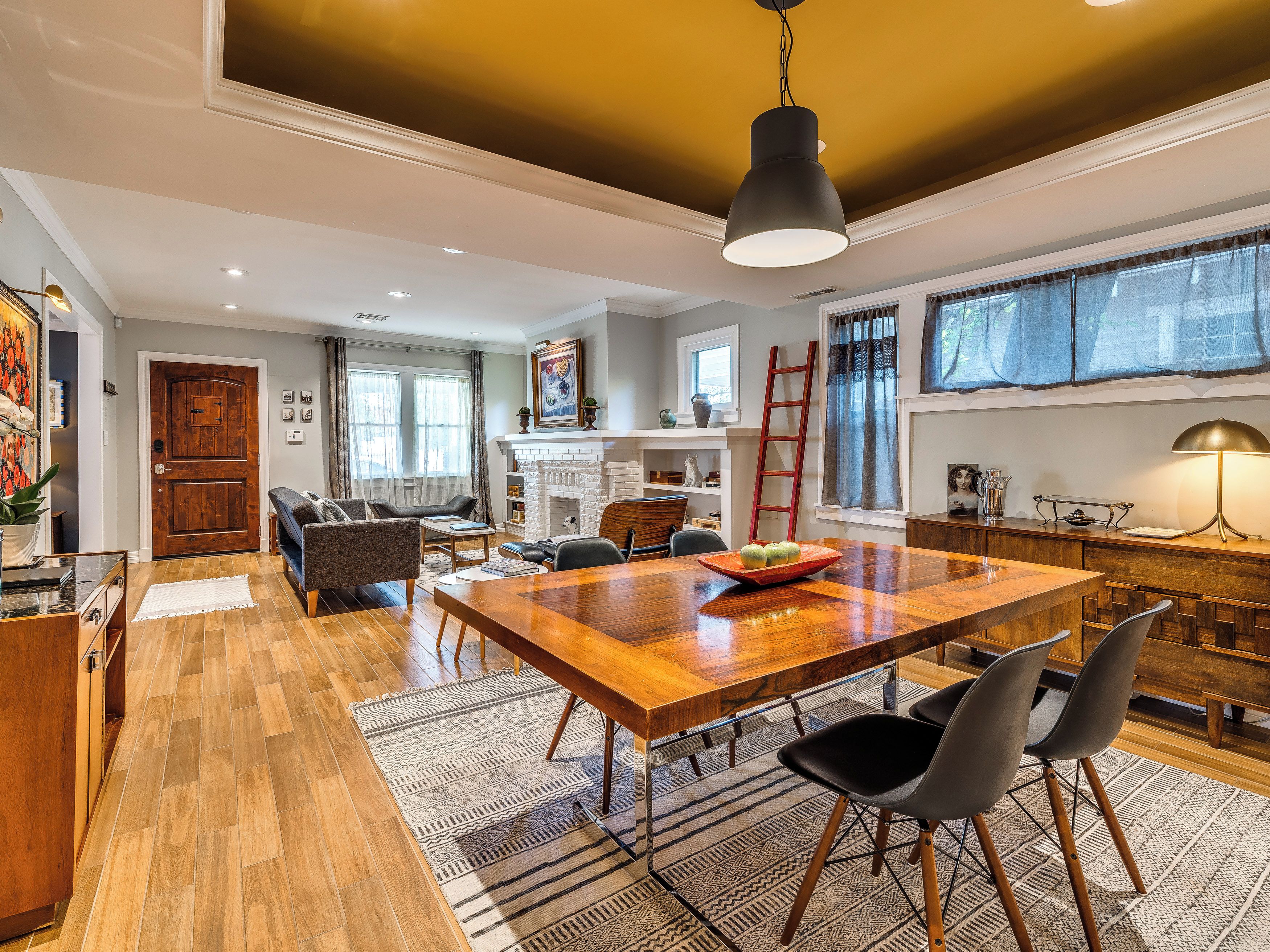 Un salón amplio con una mesa de comedor de madera, asientos cómodos y una chimenea.
