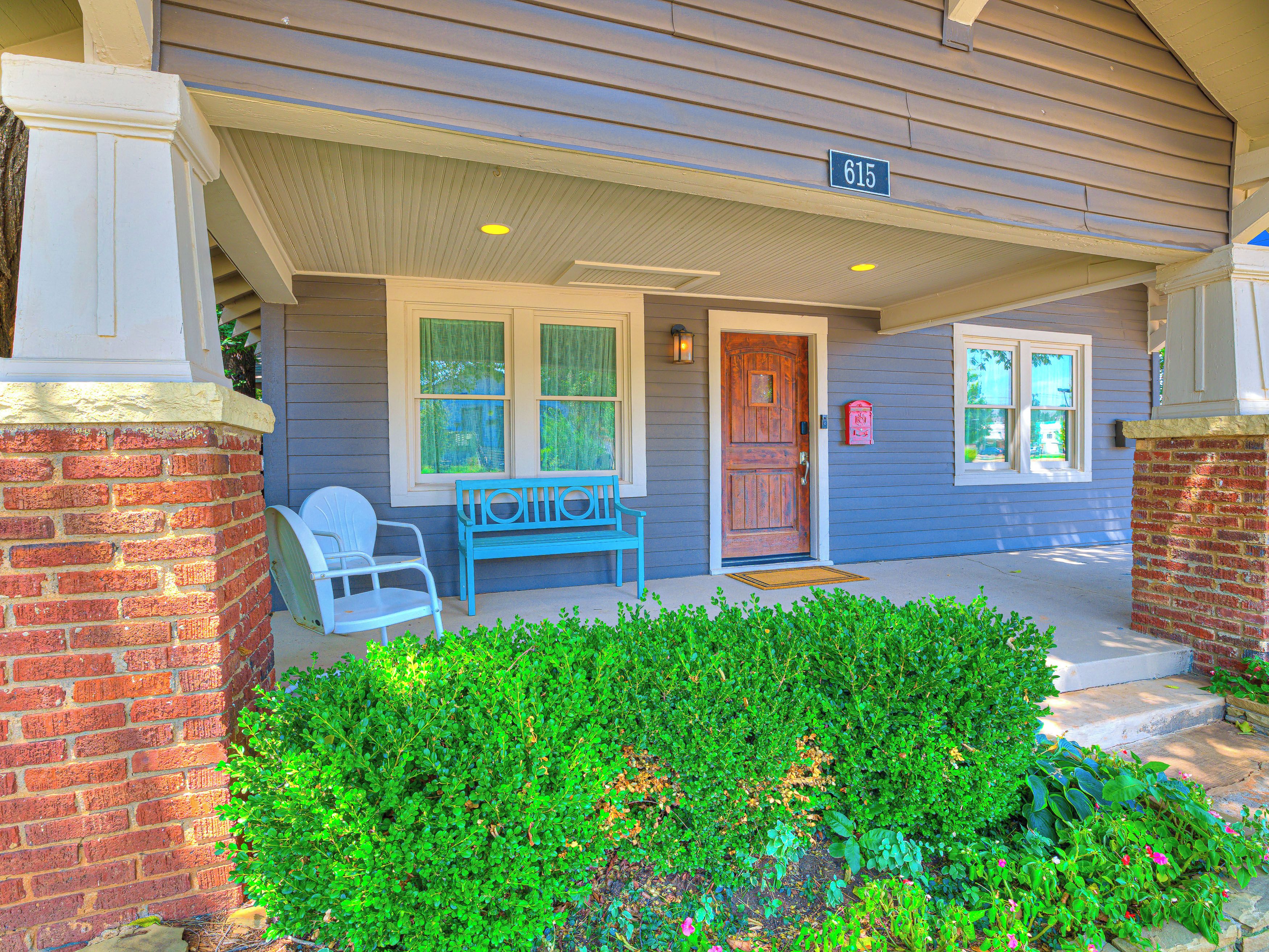 A house with a front porch, a mailbox, and a door with a number 615 sign.