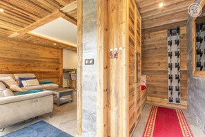 A wooden interior with a sofa, a small table, and a red carpet. - CHALET LE 1244 - CHAMPAGNY EN VANOISE (CHAMPAGNY EN VANOISE)