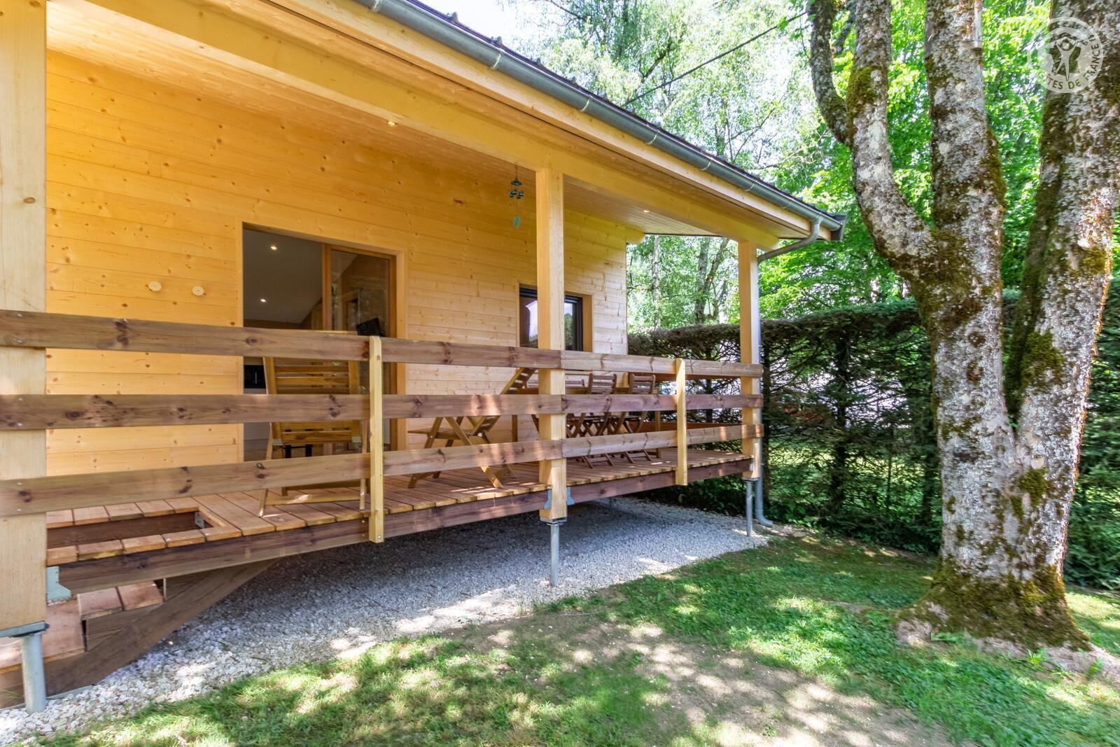 A wooden cabin with a porch, a door, and a window.