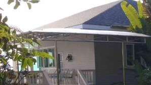 A single-story building with a covered porch and a staircase leading to a deck.