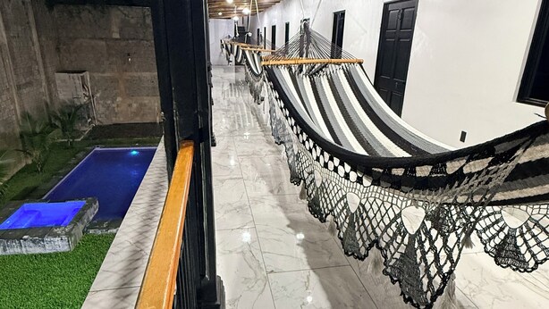 A corridor with a hammock, a pool, and a staircase. - La Casona Suchitoto  (Suchitoto)