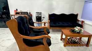 A living room with a sofa, two armchairs, a coffee table, and a small table with a coffee machine and a bottle. - La Casona Suchitoto  (Suchitoto)