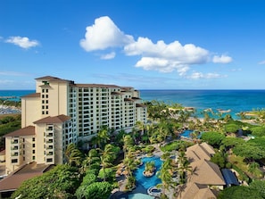 Un resort con diversi edifici, una piscina e vista sull'oceano.