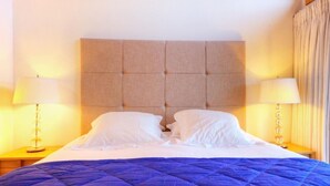 A hotel room with a large bed, two bedside lamps, and a headboard. - Teychenne Mungo by Interhome (Thyon-Les Collons)