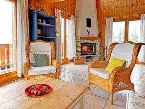 A cozy room with wicker chairs, a fireplace, and a wooden interior. - Chalet Krokus by Interhome (Thyon-Les Collons)