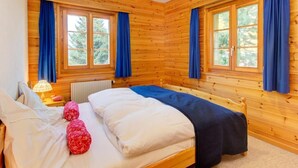 A wooden cabin bedroom with two beds, a window, and a lamp. - Chalet Altitude 1900 by Interhome (Thyon-Les Collons)