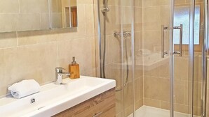 A modern bathroom with a glass shower enclosure, a wooden vanity, and a large mirror. - Chalet Altitude 1900 by Interhome (Thyon-Les Collons)