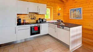 A modern kitchen with white cabinets, a built-in oven, a coffee maker, and a sink. - Chalet Bryher by Interhome (Thyon-Les Collons)