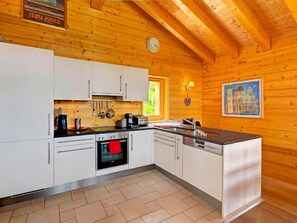 A modern kitchen with white cabinets, a built-in oven, a coffee maker, and a sink. - Chalet Bryher by Interhome (Thyon-Les Collons)