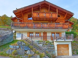 A wooden chalet with a balcony, a stone staircase, and a garage. - Roche des 4 Vallées by Interhome (Hérémence)