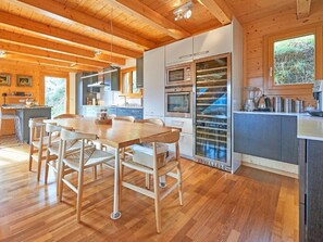 A wooden interior with a dining area, kitchen, and built-in wine storage. - Roche des 4 Vallées by Interhome (Hérémence)