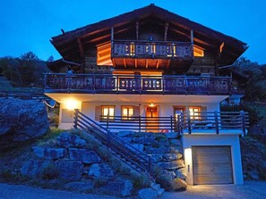 A two-story chalet with a balcony, stone steps, and a garage. - Roche des 4 Vallées by Interhome (Hérémence)