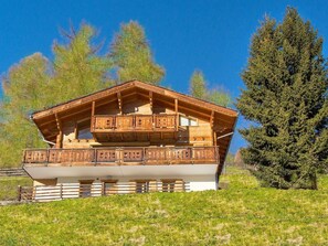 Eine Holzhütte mit Balkon, umgeben von Bäumen.