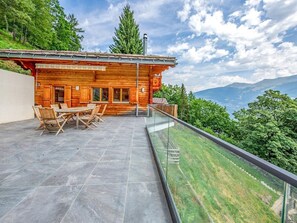 Una cabaña de madera con balcón y vistas a un paisaje montañoso.