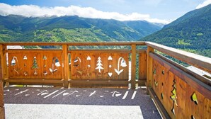 Un balcón de madera con vistas a un paisaje montañoso.