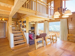 Un interno in legno con una scala, un'area pranzo e un soggiorno con vista.