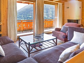 Un soggiorno accogliente con un tavolino in vetro, due divani e una poltrona con motivi decorativi.