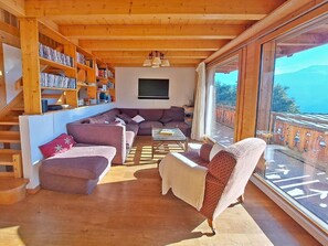 Un vaste espace de vie comprenant un canapé, une table basse et une bibliothèque remplie de livres.