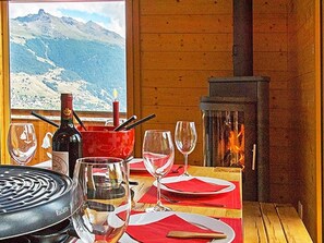 Une table à manger avec des verres à vin, une bouteille et une cheminée.
