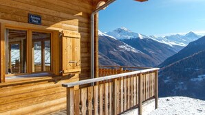 A wooden cabin with a sign reading 'Falcons Nest' and a view of snow-covered mountains. - Chalet Falcons Nest by Interhome (Hérémence)