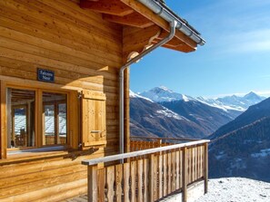 A wooden cabin with a sign reading 'Falcons Nest' and a view of snow-covered mountains. - Chalet Falcons Nest by Interhome (Hérémence)