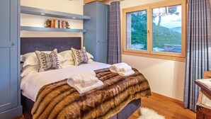 A bedroom with a bed, a window, a bookshelf, and a ceiling light. - Chalet des Etoiles by Interhome (Hérémence)