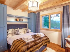 A bedroom with a bed, a window, a bookshelf, and a ceiling light. - Chalet des Etoiles by Interhome (Hérémence)