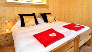 A wooden-paneled room with a bed, a nightstand, a lamp, and a skylight. - Chalet Pierina by Interhome (La Tzoumaz)