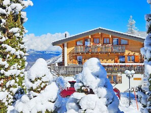 A chalet-style building with a wooden facade, multiple balconies, and a sign indicating 'Chalet Charmille.' - Chalet Charmille by Interhome (La Tzoumaz)