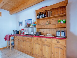 Eine Küche mit Holzausstattung, einer Arbeitsplatte und verschiedenen Küchengegenständen.