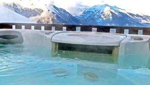 Un jacuzzi con vistas a montañas nevadas.