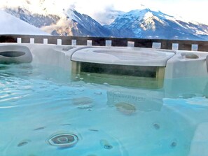 Ein Whirlpool mit Blick auf schneebedeckte Berge.